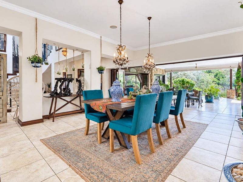 Spacious dining area featuring tiled flooring, crown molding, and large bi-fold doors that open onto an outdoor patio area.