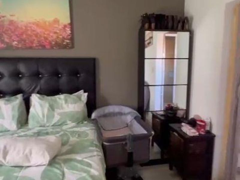 A bedroom featuring laminate flooring and neutral wall tones, providing a functional space for rest.