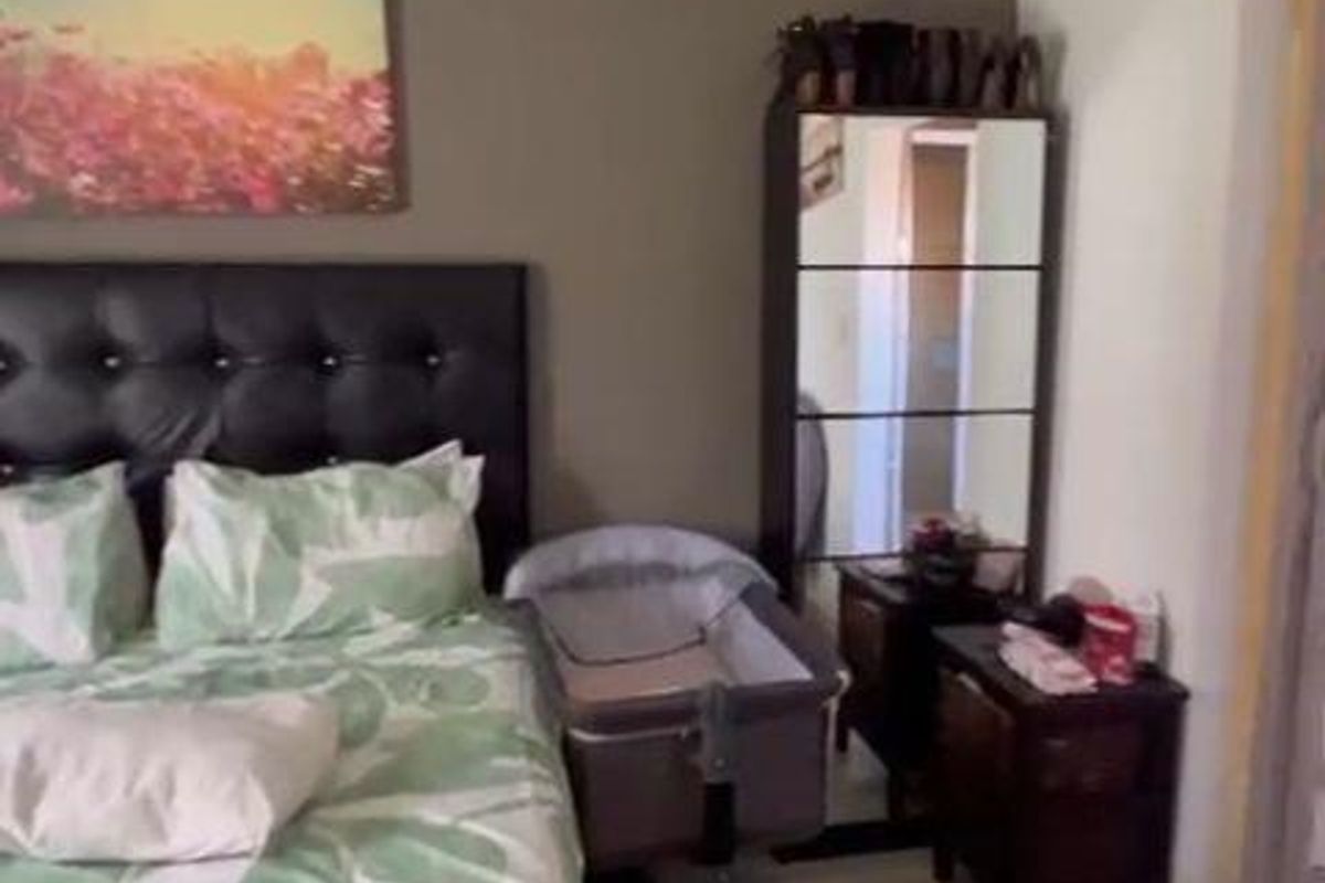 A bedroom featuring laminate flooring and neutral wall tones, providing a functional space for rest.