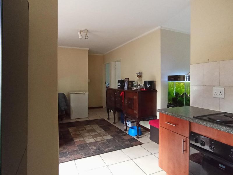 Open plan kitchen and living area featuring tiled flooring, granite countertops, and built-in cooking appliances, offering a functional layout for daily living.