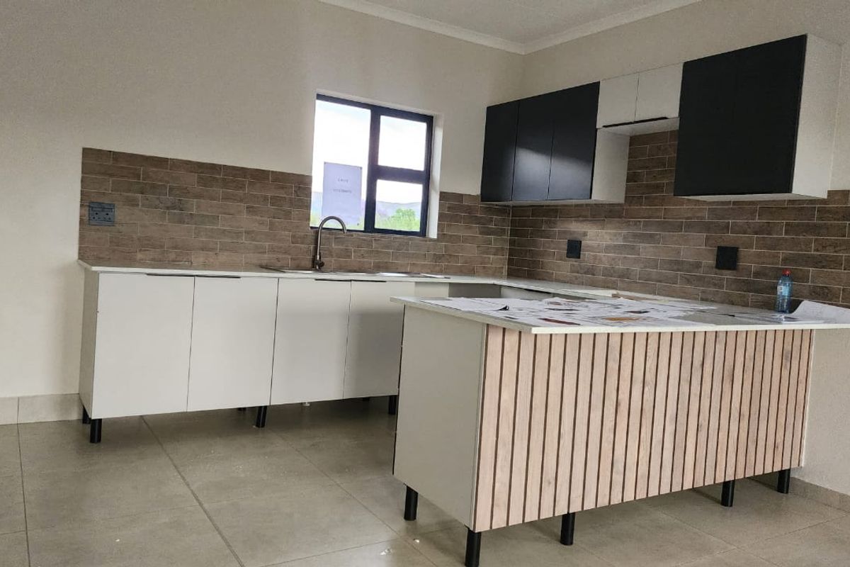 Modern kitchen featuring sleek white and black cabinetry, a wood-slat kitchen island, tiled backsplash, and neutral floor tiles in a clean, open space.