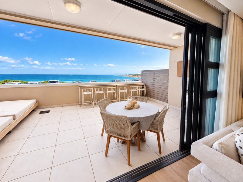 Spacious covered balcony featuring tiled flooring, a built-in breakfast bar, and seamless indoor-outdoor flow with stunning ocean views.