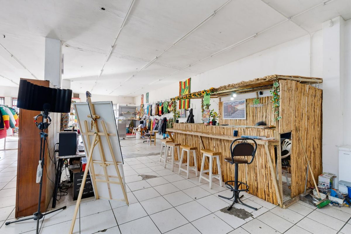 Open-plan retail space featuring tiled flooring and exposed ceiling, currently utilized with a custom bamboo-style service counter.