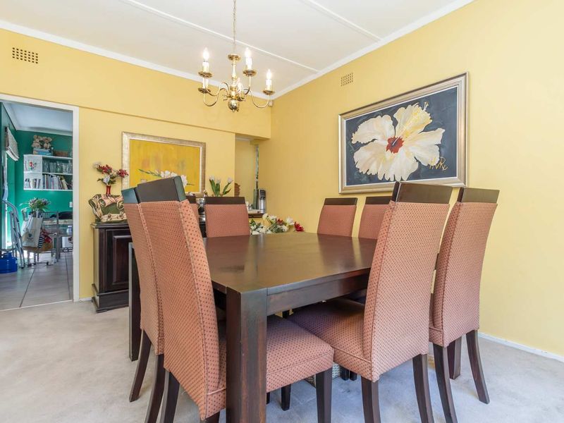 A dining room featuring yellow walls, a coved ceiling, and a central light fixture, providing a functional space for meals.