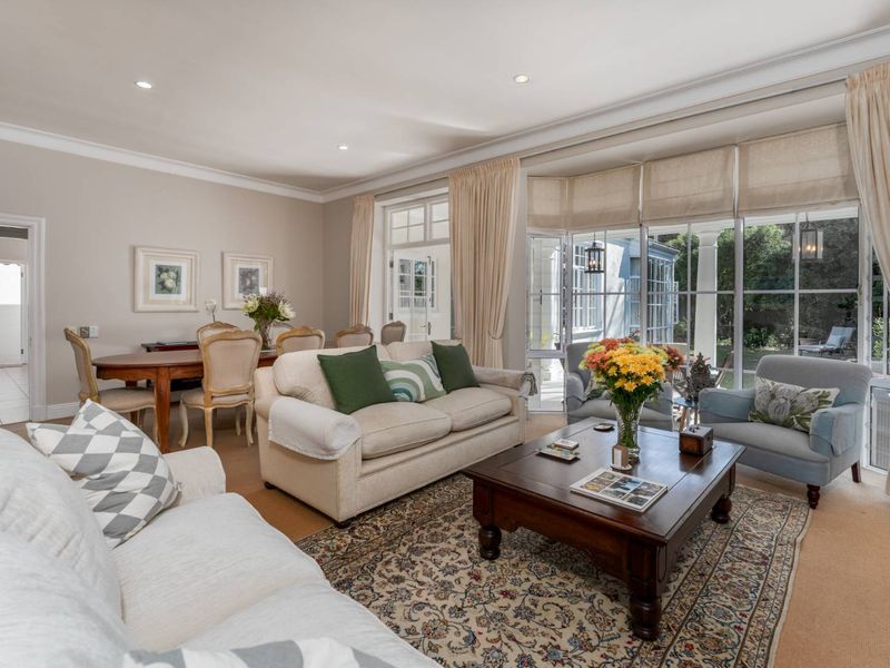 Spacious open-plan living and dining area featuring large glass doors that provide abundant natural light and seamless access to the outdoor patio.