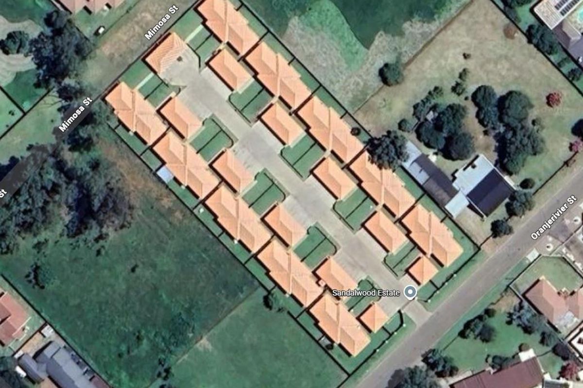 An aerial view of the Sandalwood Estate townhouse complex, showing the layout of the residential units, internal access roads, and surrounding neighborhood streets.