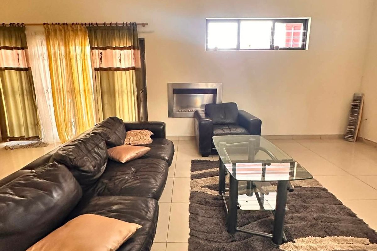 Spacious living room featuring tiled flooring, a built-in fireplace, and a wall-mounted air conditioning unit.