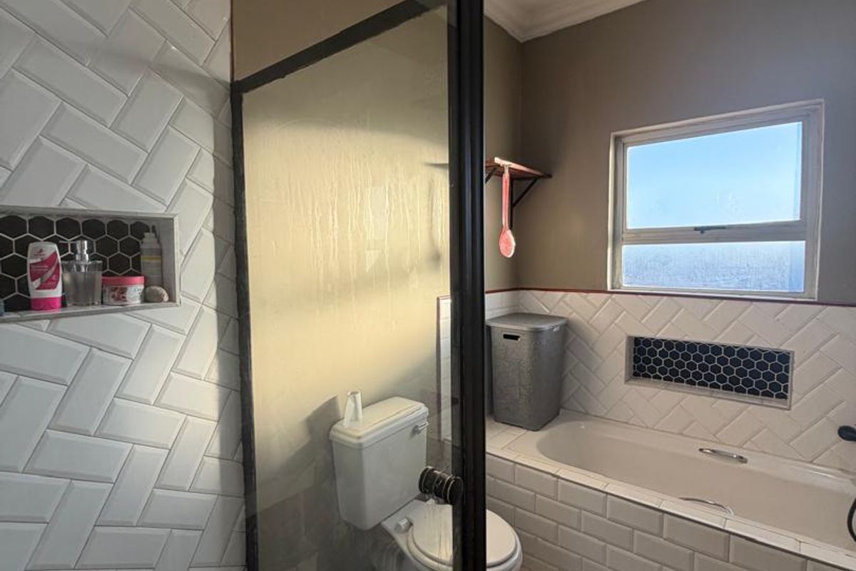Modern bathroom featuring a glass-enclosed shower with subway tiles, a built-in bathtub, and stylish hexagonal mosaic accents.