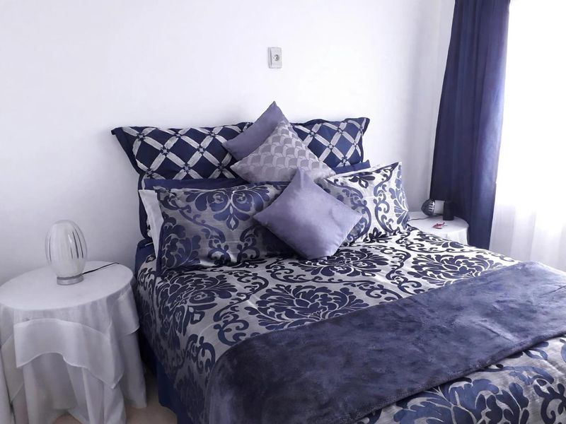 A bedroom featuring neutral wall finishes and a window with curtains, providing a functional space for rest.