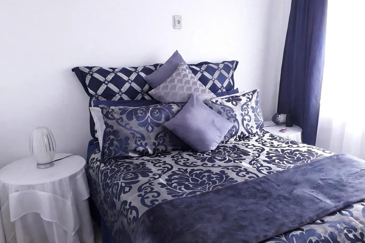 A bedroom featuring neutral wall finishes and a window with curtains, providing a functional space for rest.