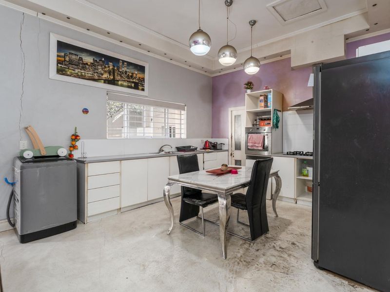 A functional kitchen featuring built-in cabinetry, integrated oven, and gas hob, requiring cosmetic updates to the walls and flooring to enhance its appeal.