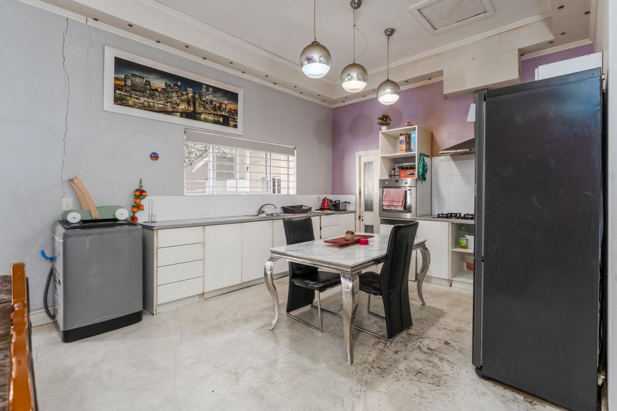 A functional kitchen featuring built-in cabinetry, integrated oven, and gas hob, requiring cosmetic updates to the walls and flooring to enhance its appeal.