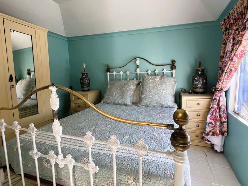 A cozy bedroom featuring a vaulted ceiling and a built-in wardrobe, offering a comfortable and functional sleeping space.