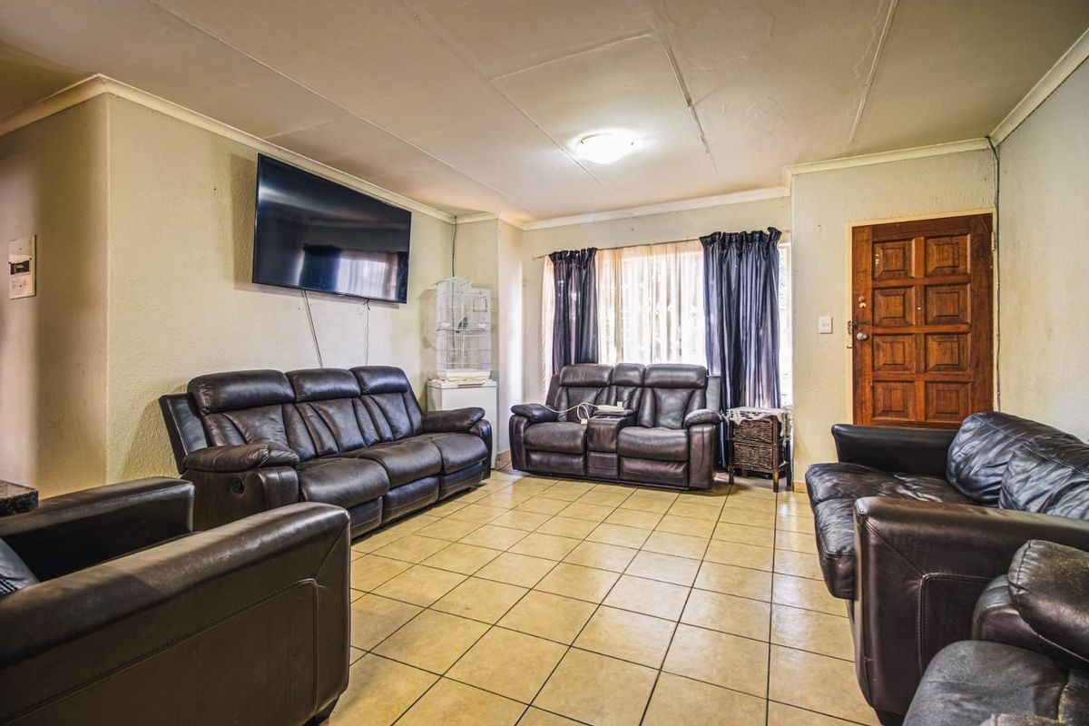 A spacious living room featuring tiled flooring and a coved ceiling, providing a functional base for comfortable family living.