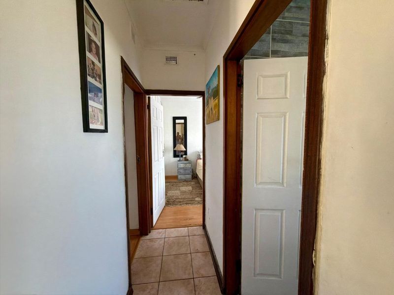 A functional hallway featuring tiled flooring and wooden door frames, providing access to adjacent rooms within the townhouse.