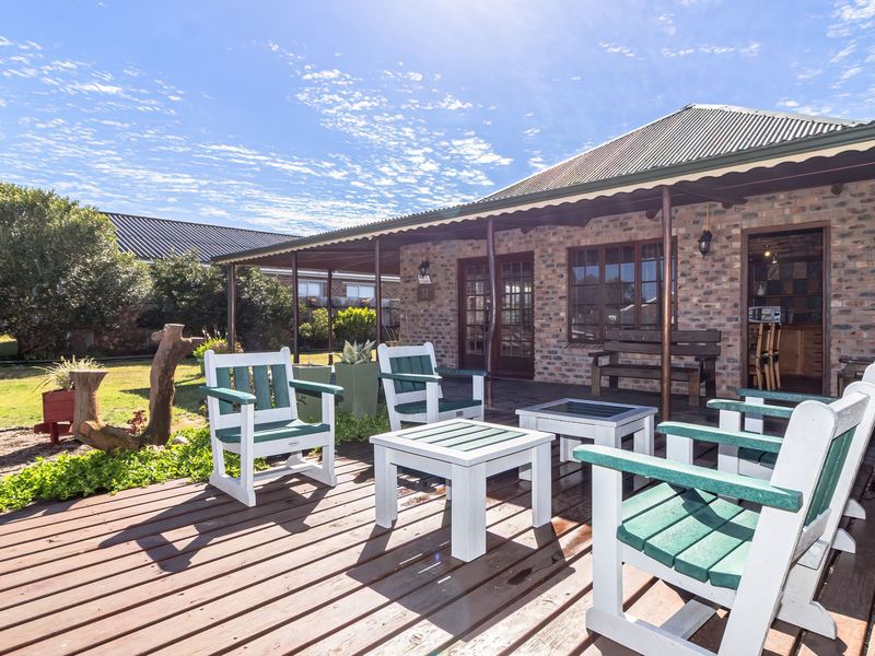 A covered outdoor patio area featuring timber decking and an exposed brick facade, providing a functional space for outdoor relaxation.