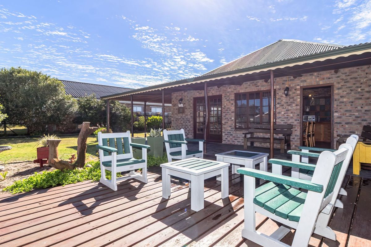 A covered outdoor patio area featuring timber decking and an exposed brick facade, providing a functional space for outdoor relaxation.