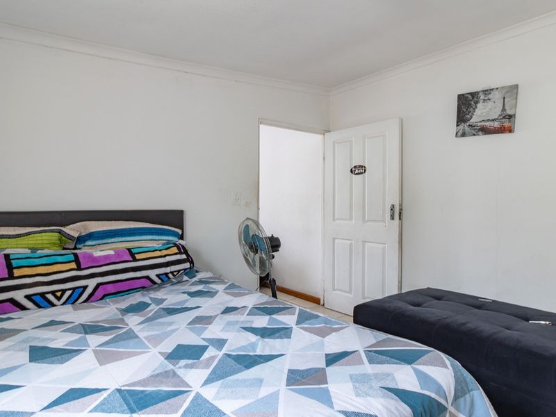 A standard bedroom featuring white walls, coving, and a traditional panelled door, offering a neutral base for potential interior updates.