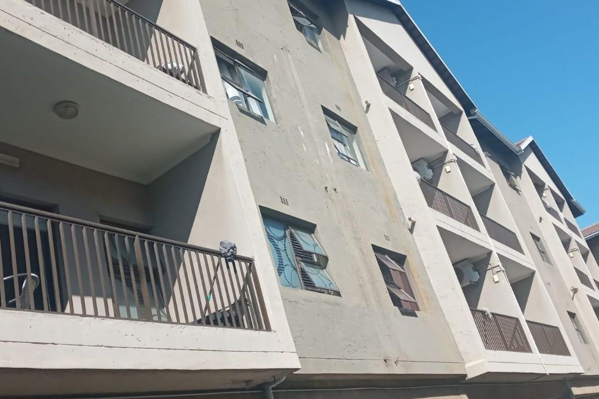Exterior view of an apartment building facade featuring multiple balconies with metal railings and standard casement windows.