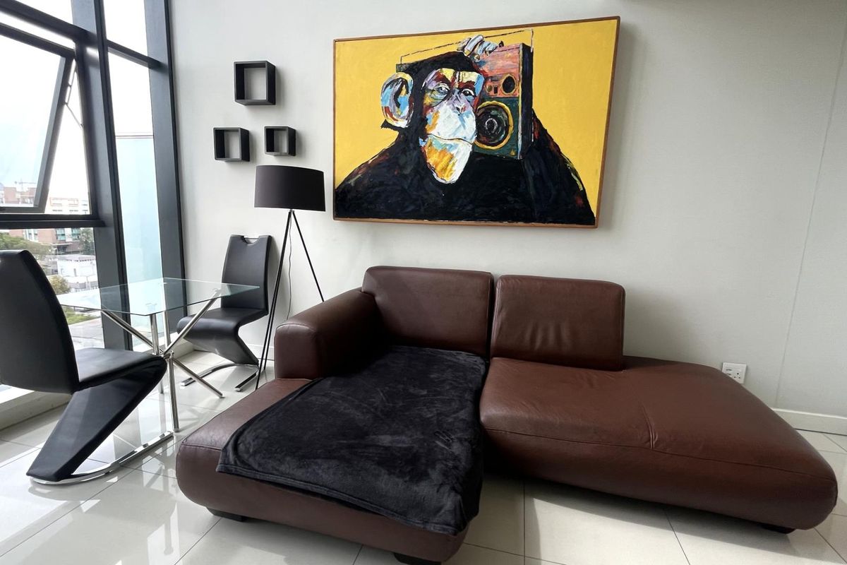 A modern living area featuring large floor-to-ceiling windows with natural light and polished tile flooring.