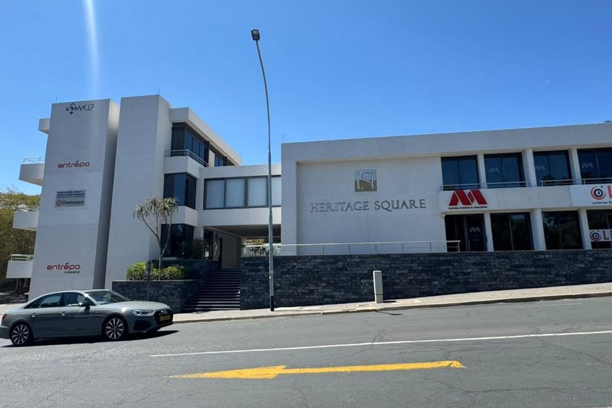 Front exterior view of Heritage Square office building featuring modern white facade, stone base, and prominent corporate signage.