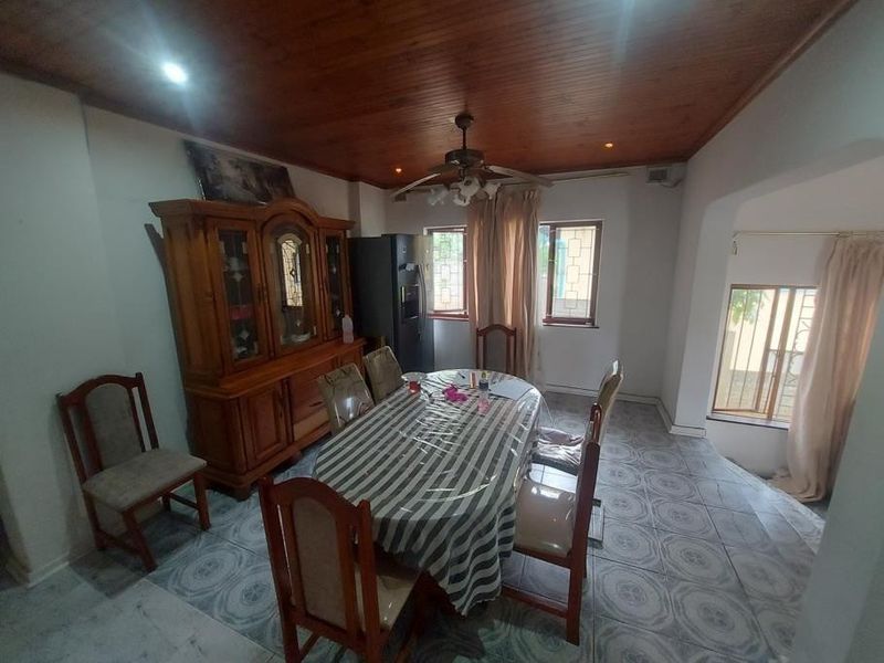 Dining room featuring a timber ceiling, ceiling fan, and tiled flooring, offering a functional space for family meals.
