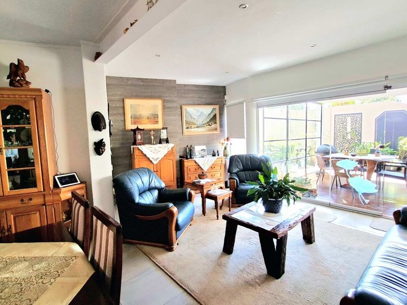 Spacious open-plan living area featuring large sliding glass doors that provide seamless access to the outdoor patio and garden.