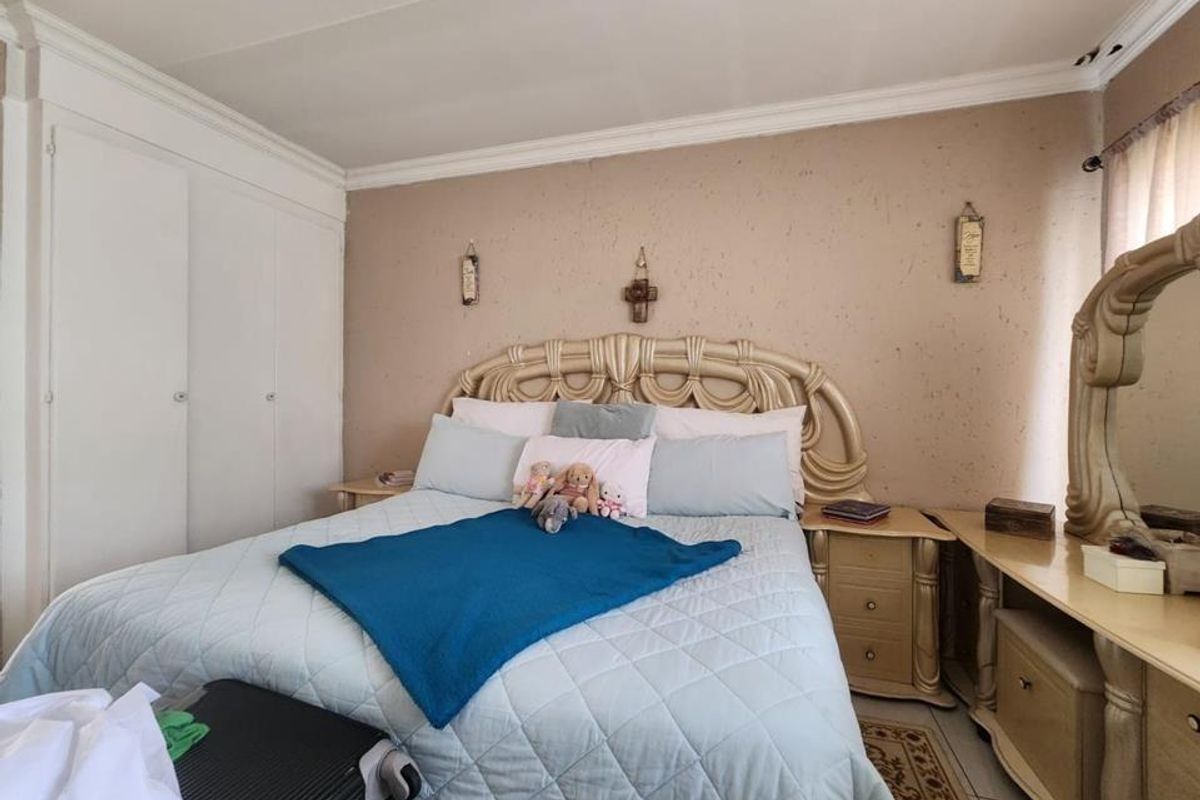 A bedroom featuring built-in cupboards with white doors and crown molding, providing functional storage space.