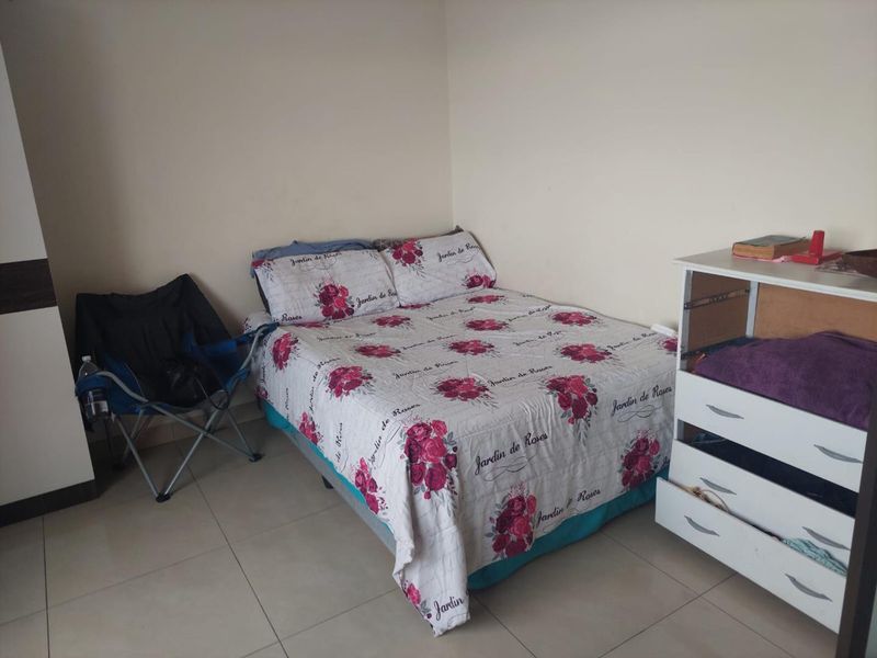 A functional bedroom featuring tiled flooring and a built-in wardrobe, offering a neutral base for personalization.