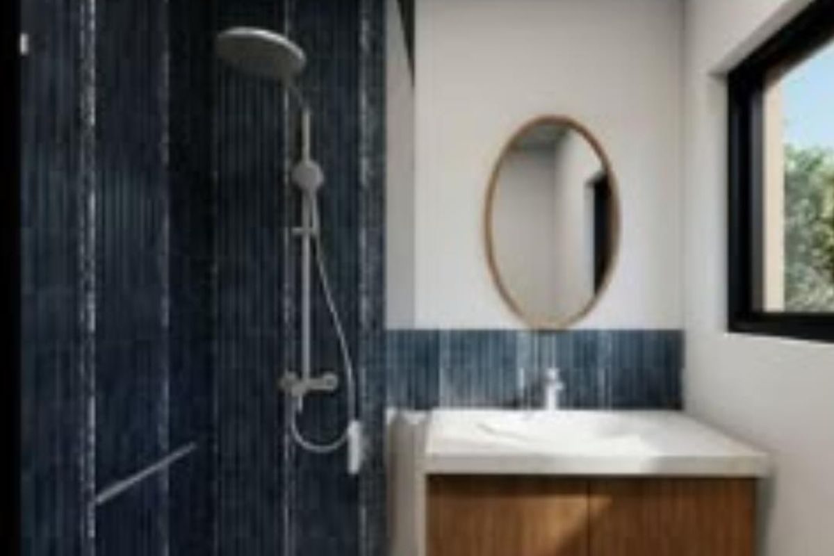 Modern bathroom featuring a wall-mounted vanity, basin, and a shower with dark blue tiled walls.