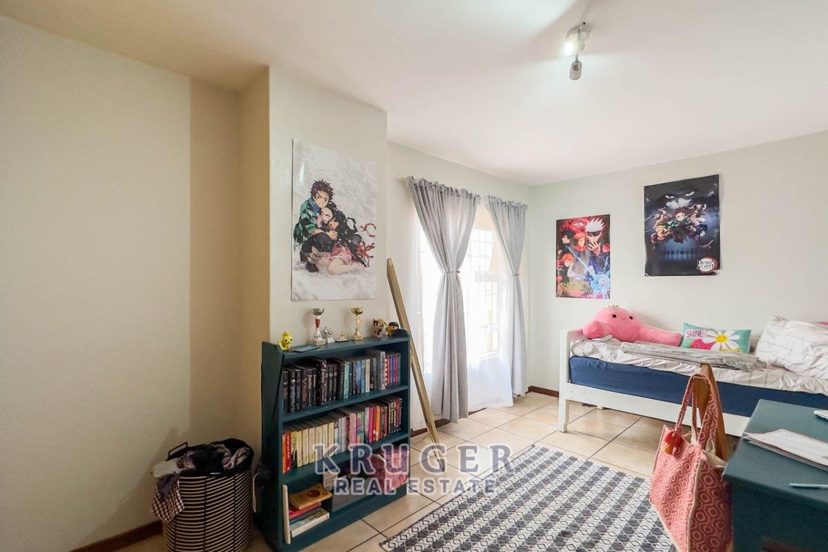 A bedroom featuring tiled flooring and a built-in wardrobe, offering a functional space with natural light.