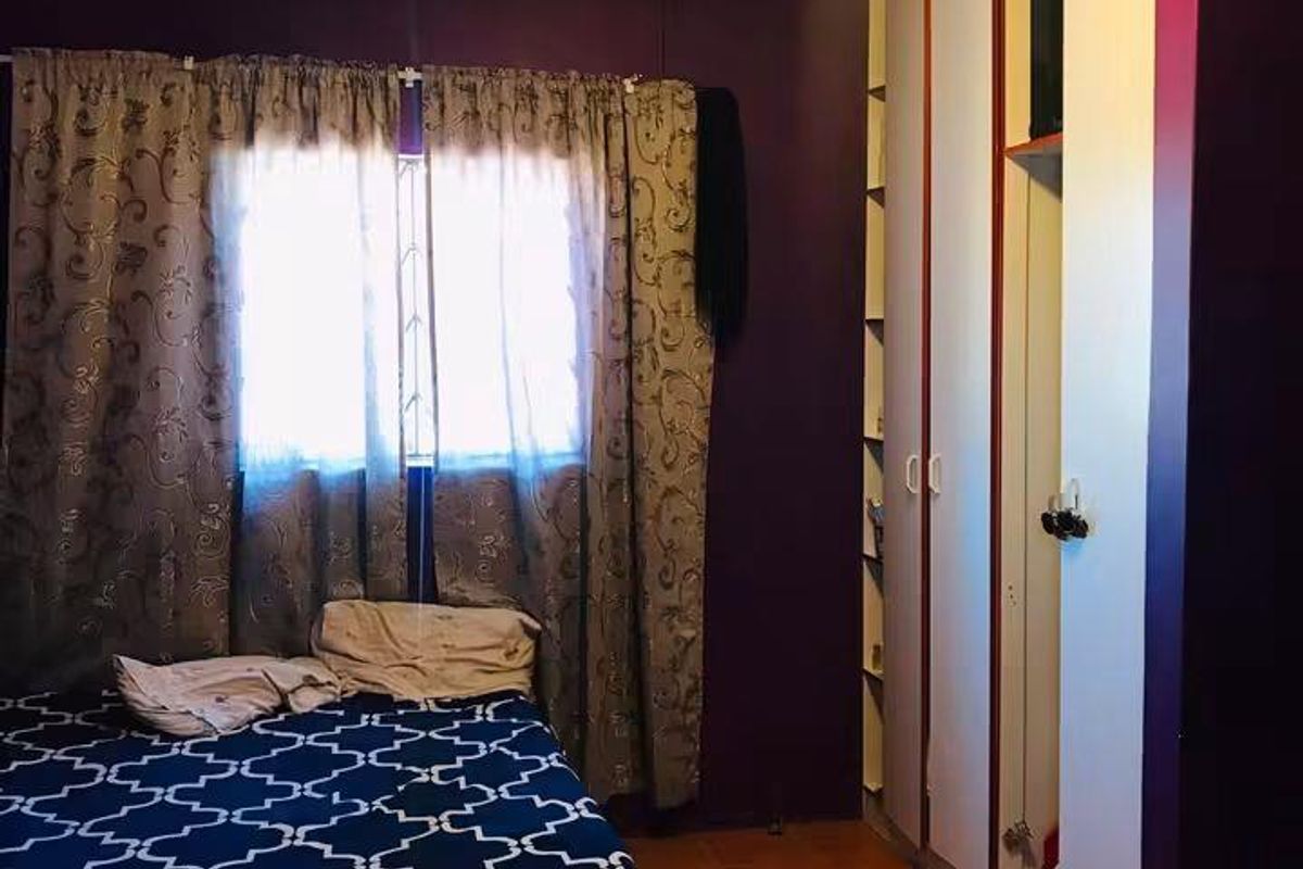 A bedroom featuring tiled flooring and a built-in wardrobe with integrated shelving.