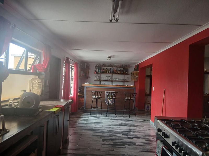 A dedicated bar area featuring a built-in counter, fixed shelving, and tiled flooring, providing a functional space for entertainment.