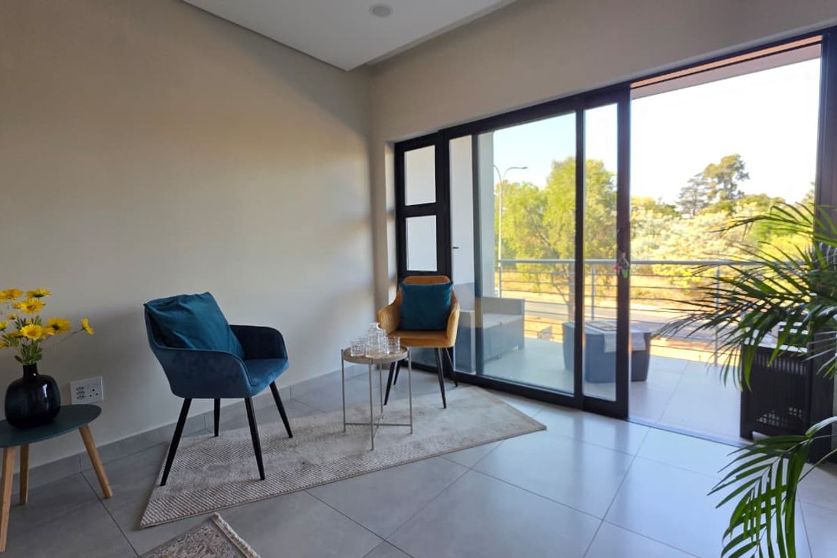 A bright living area featuring large sliding glass doors that provide seamless access to an outdoor balcony and natural light.