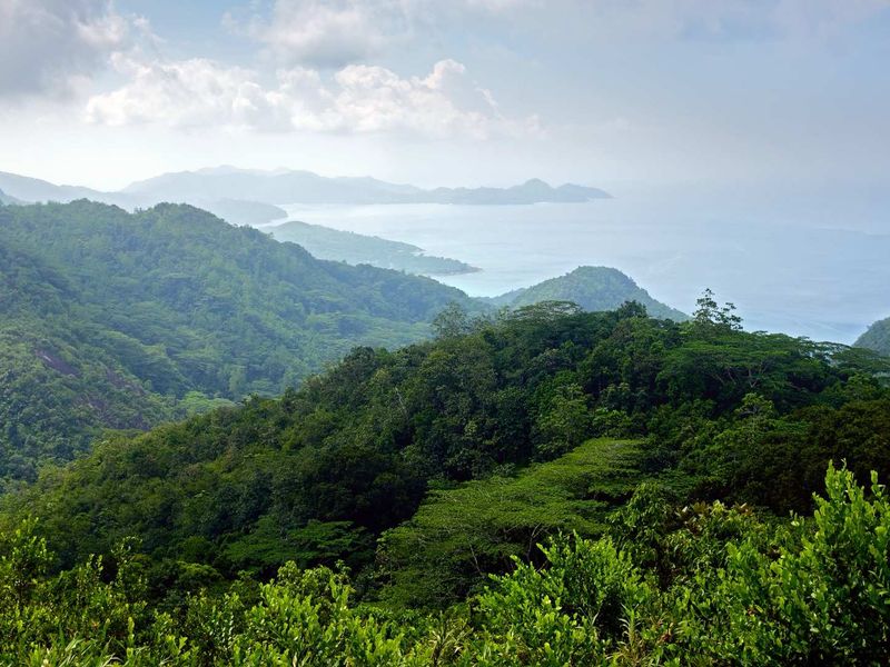 A scenic elevated view overlooking lush green mountain ranges and the distant coastline.