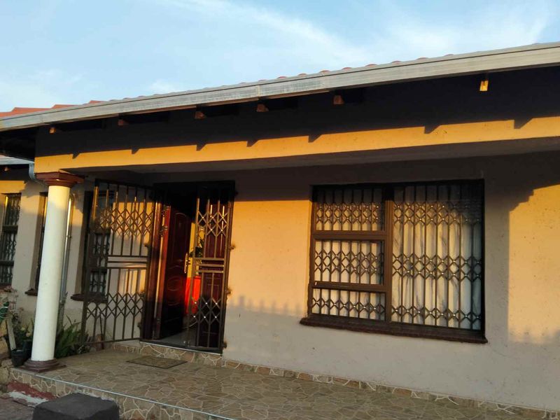 Front facade of the house featuring a covered patio, security gates, and security bars on the windows.
