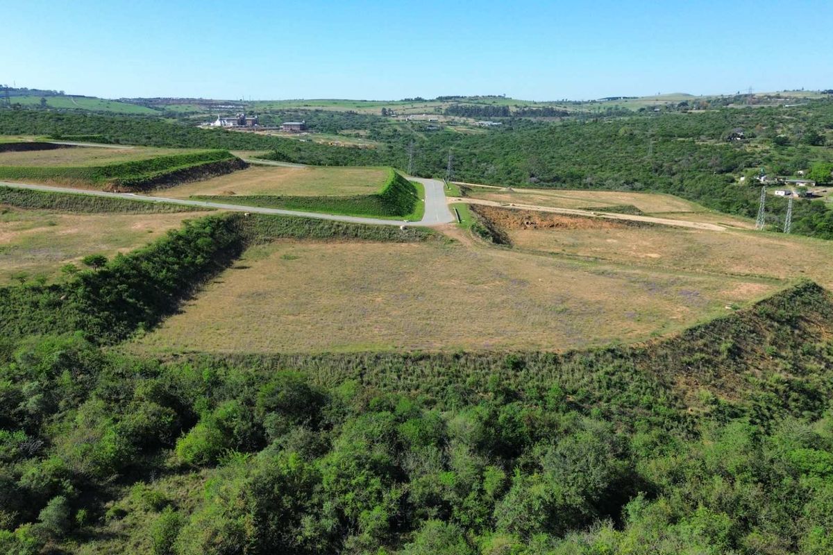 Aerial view of a large, terraced industrial land parcel featuring established access roads and surrounding natural landscape.