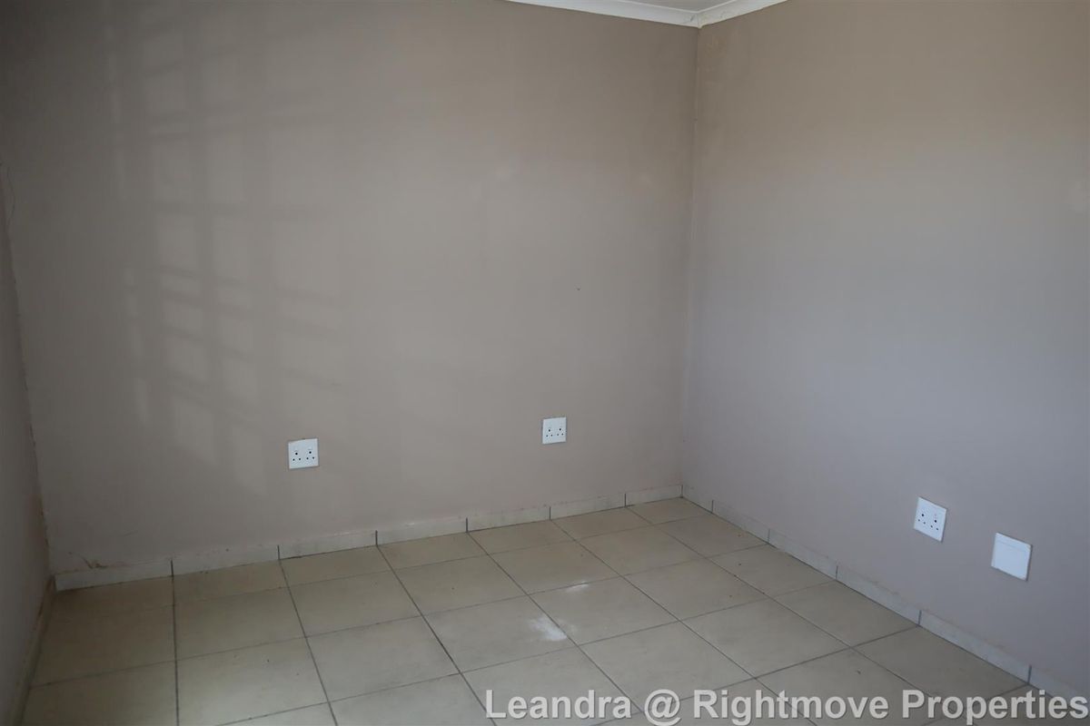 A vacant, neutral-toned room featuring tiled flooring and multiple electrical power points, suitable for use as an office or bedroom space.