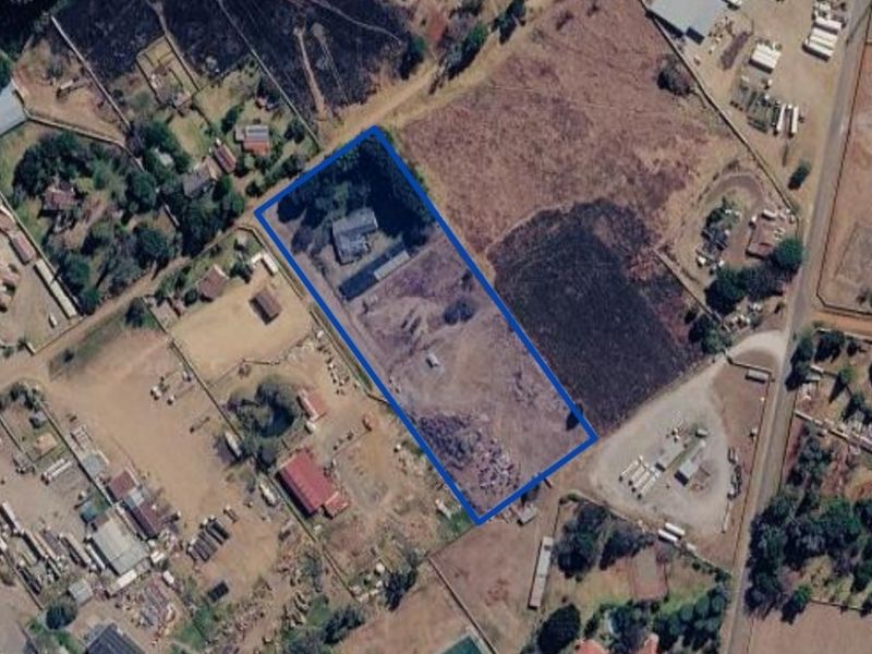 Aerial view of the small holding property highlighting the plot boundaries, main dwelling, and associated outbuildings within the fenced area.