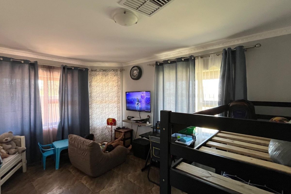 A bedroom featuring tiled flooring, decorative ceiling cornices, and built-in air conditioning ventilation.