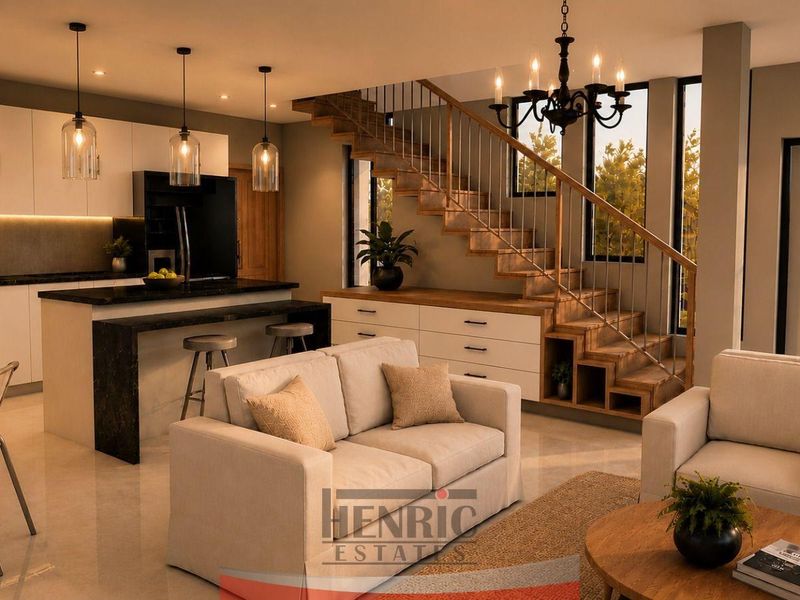Modern open-plan living area featuring a sleek kitchen with island, integrated under-stair storage, and a contemporary staircase, creating a cohesive and functional living space.