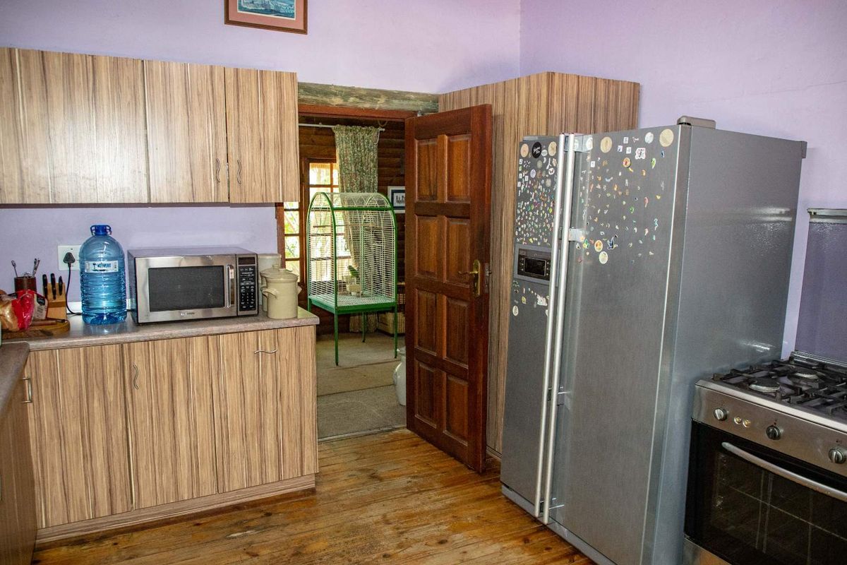 A functional kitchen featuring wood-grain cabinetry, a gas stove, and direct access to an adjoining room.