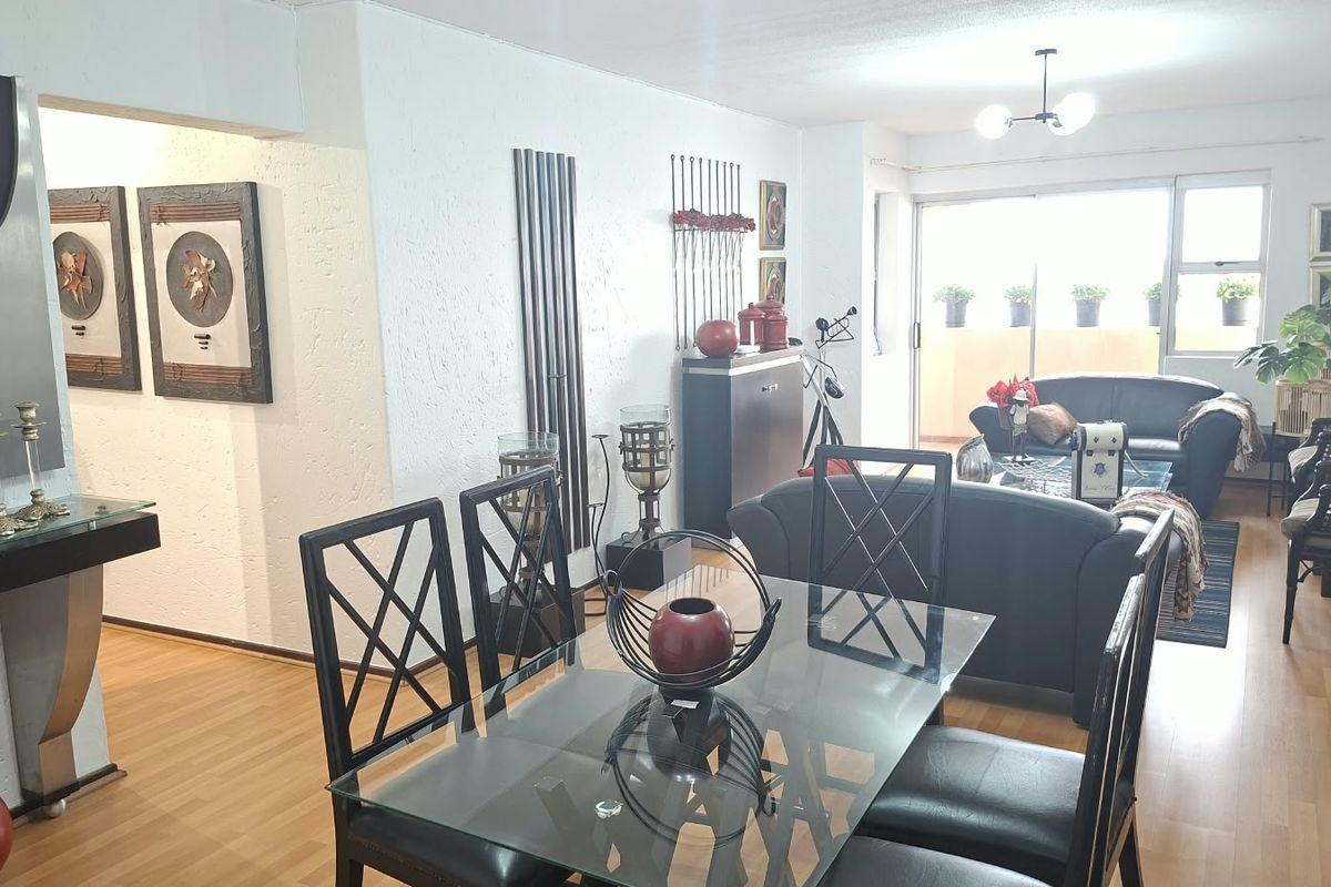 Open plan living and dining area featuring laminate flooring, textured walls, and large sliding glass doors leading to an outdoor balcony space.