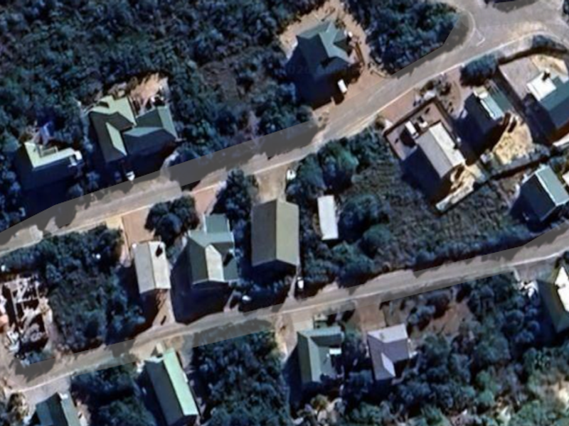 An aerial view of a residential neighborhood showing the layout of houses, roads, and surrounding vegetation.