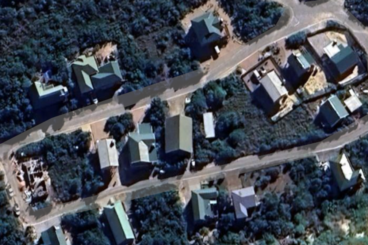 An aerial view of a residential neighborhood showing the layout of houses, roads, and surrounding vegetation.
