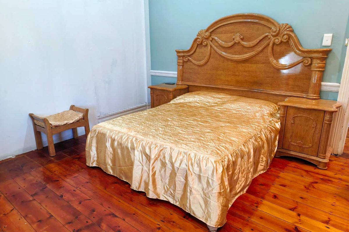 A bedroom featuring polished hardwood flooring and classic chair rail molding, providing a traditional foundation for interior updates.