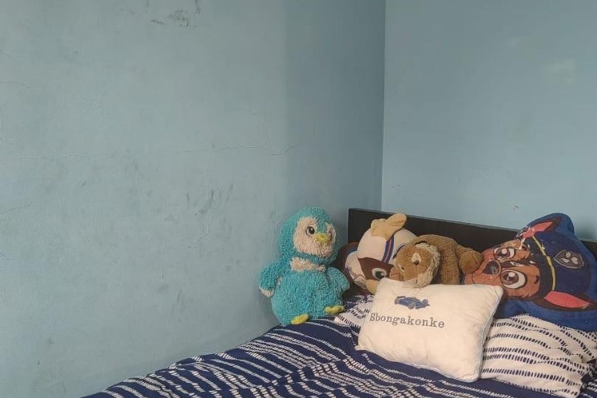 A bedroom featuring blue painted walls showing signs of wear and scuffing, providing a blank canvas for potential cosmetic updates.