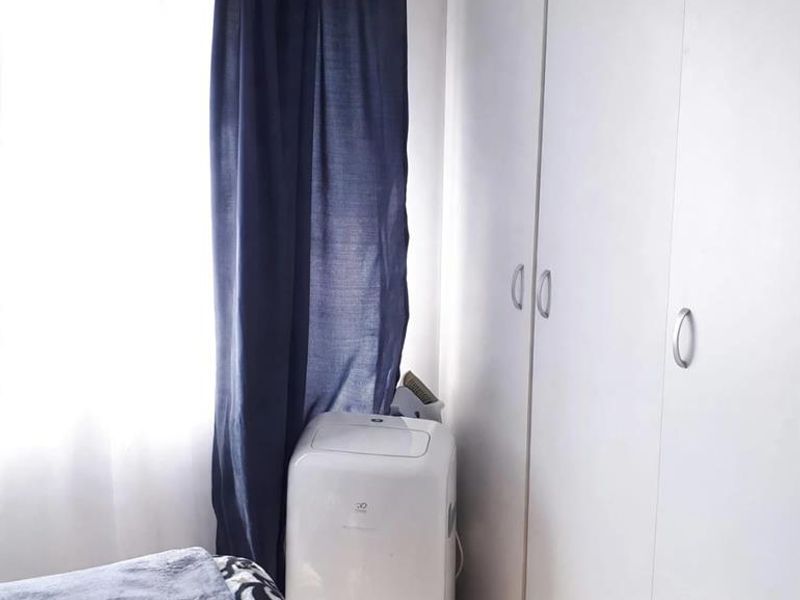A bedroom featuring built-in cupboards and tiled flooring, providing functional storage space.