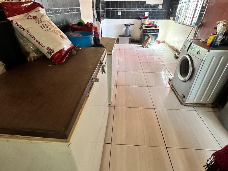 A functional kitchen space featuring tiled flooring, a timber ceiling, and tiled splashbacks, offering a practical layout for daily culinary activities.