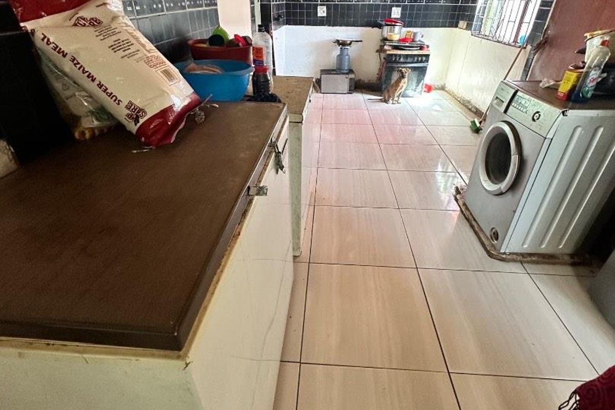 A functional kitchen space featuring tiled flooring, a timber ceiling, and tiled splashbacks, offering a practical layout for daily culinary activities.